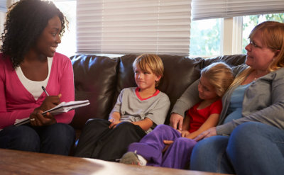 woman talking to two children and their mother