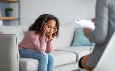 unhappy girl listening to psychologist at meeting