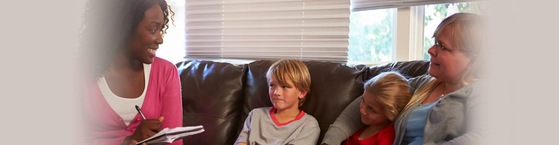 woman talking to two children and their mother